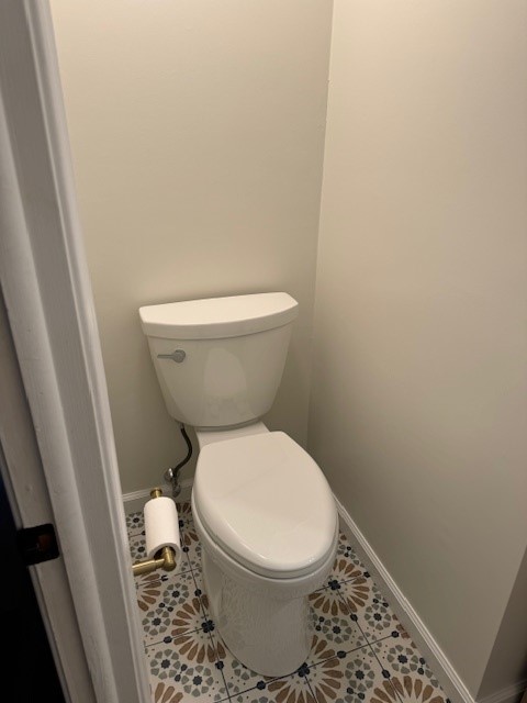 New toilet and patterned bathroom tile after a small bathroom renovation