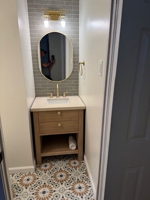Bathroom vanity, mirror, lighting, and patterned tile floor