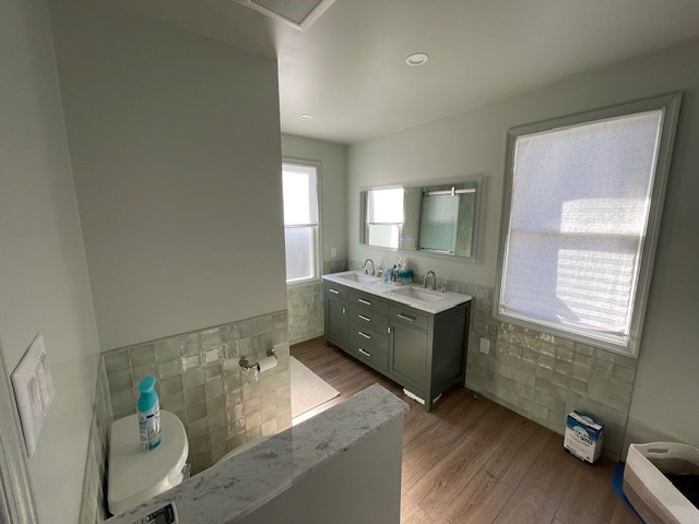 Completed bathroom renovation with vanity, tile, and toilet area